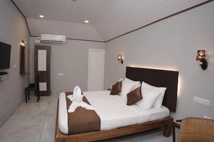 Room with wall-mounted TV and queen bed